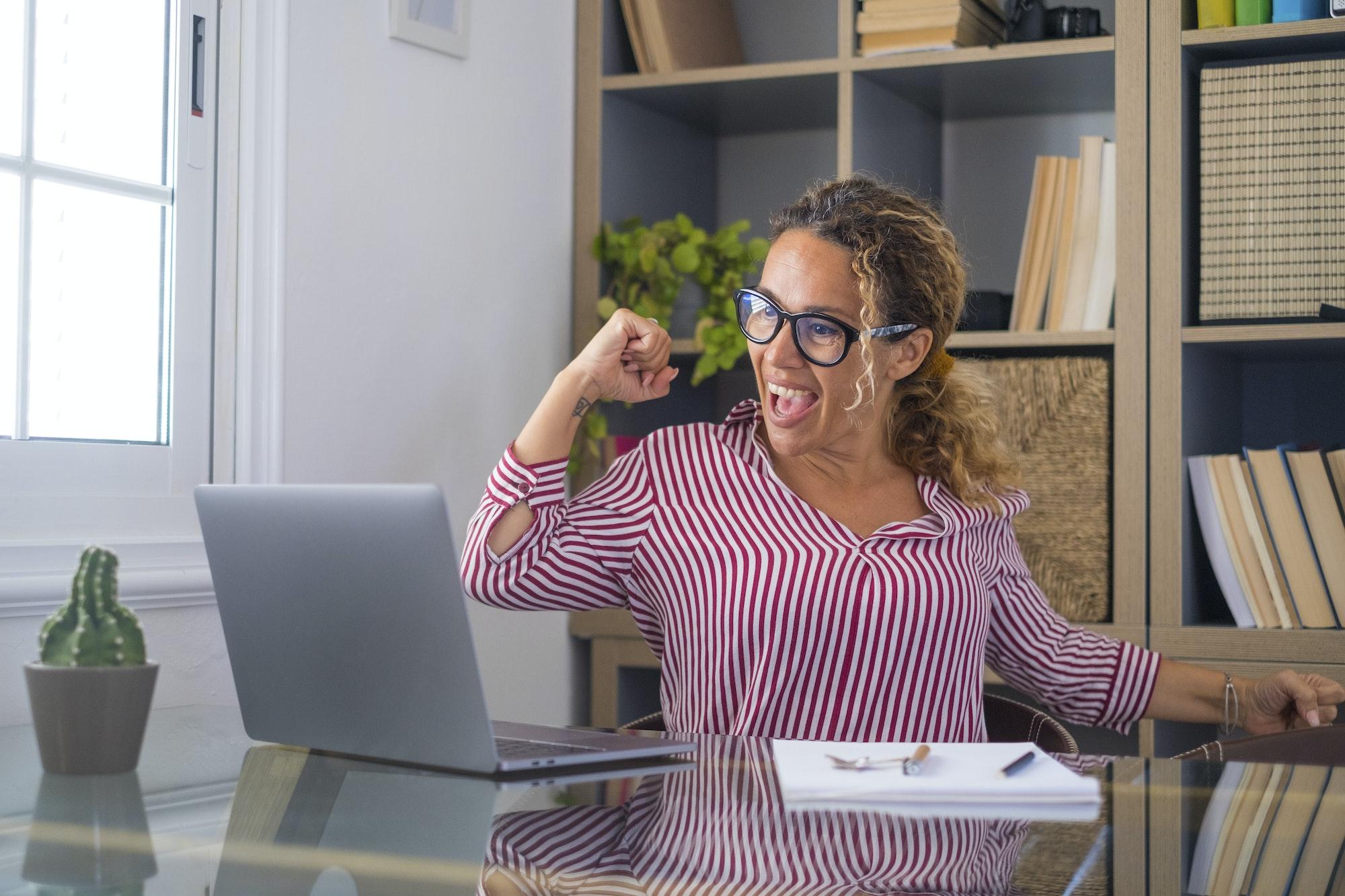 Caucasian woman office worker feeling excited raising fist celebrating career promotion or reward