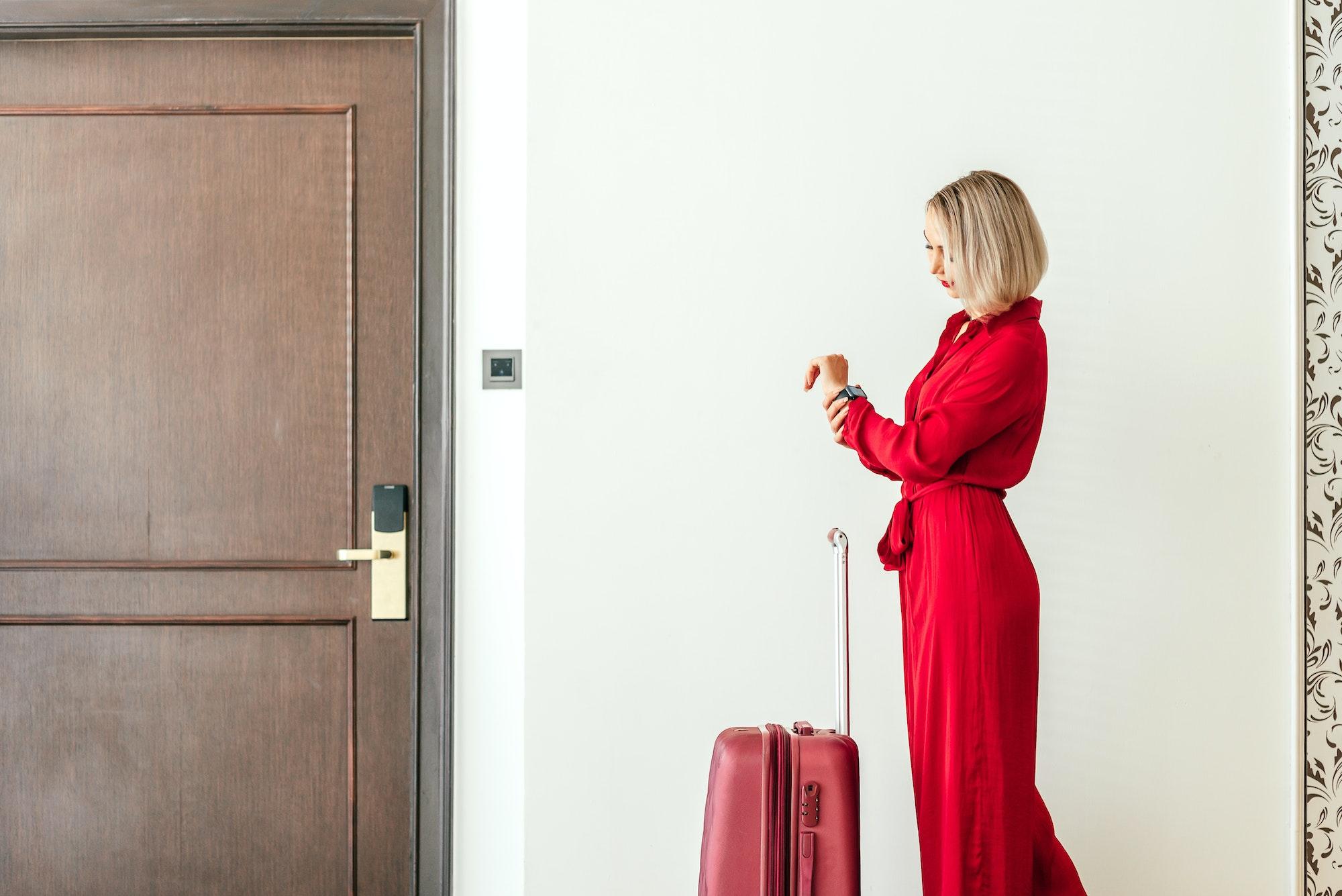 Waiting... Attractive businesswoman waiting near hotel room in the luxury hotel.