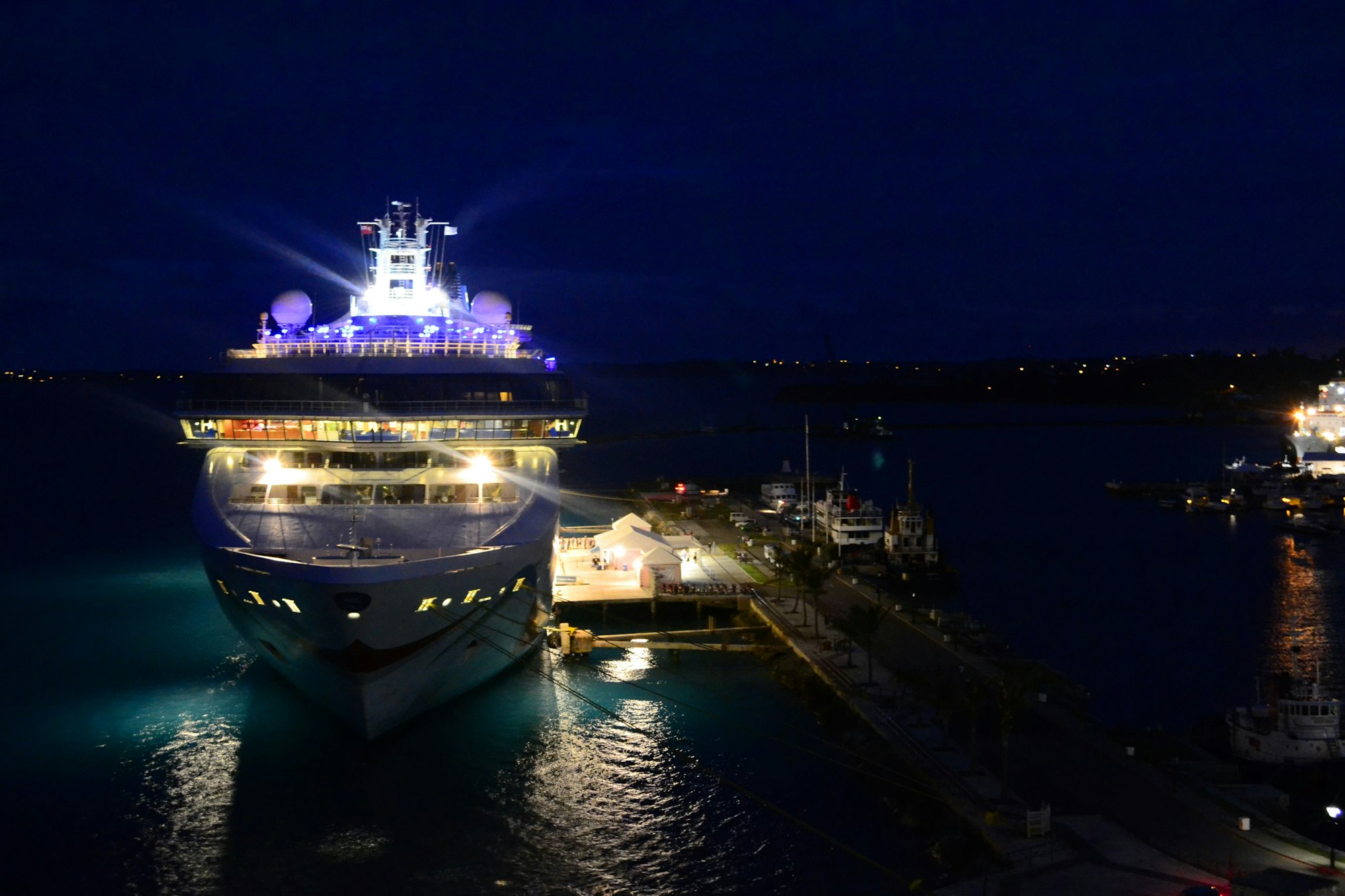 A cruise ship at night with all the lights on in port on the island of Bermuda.