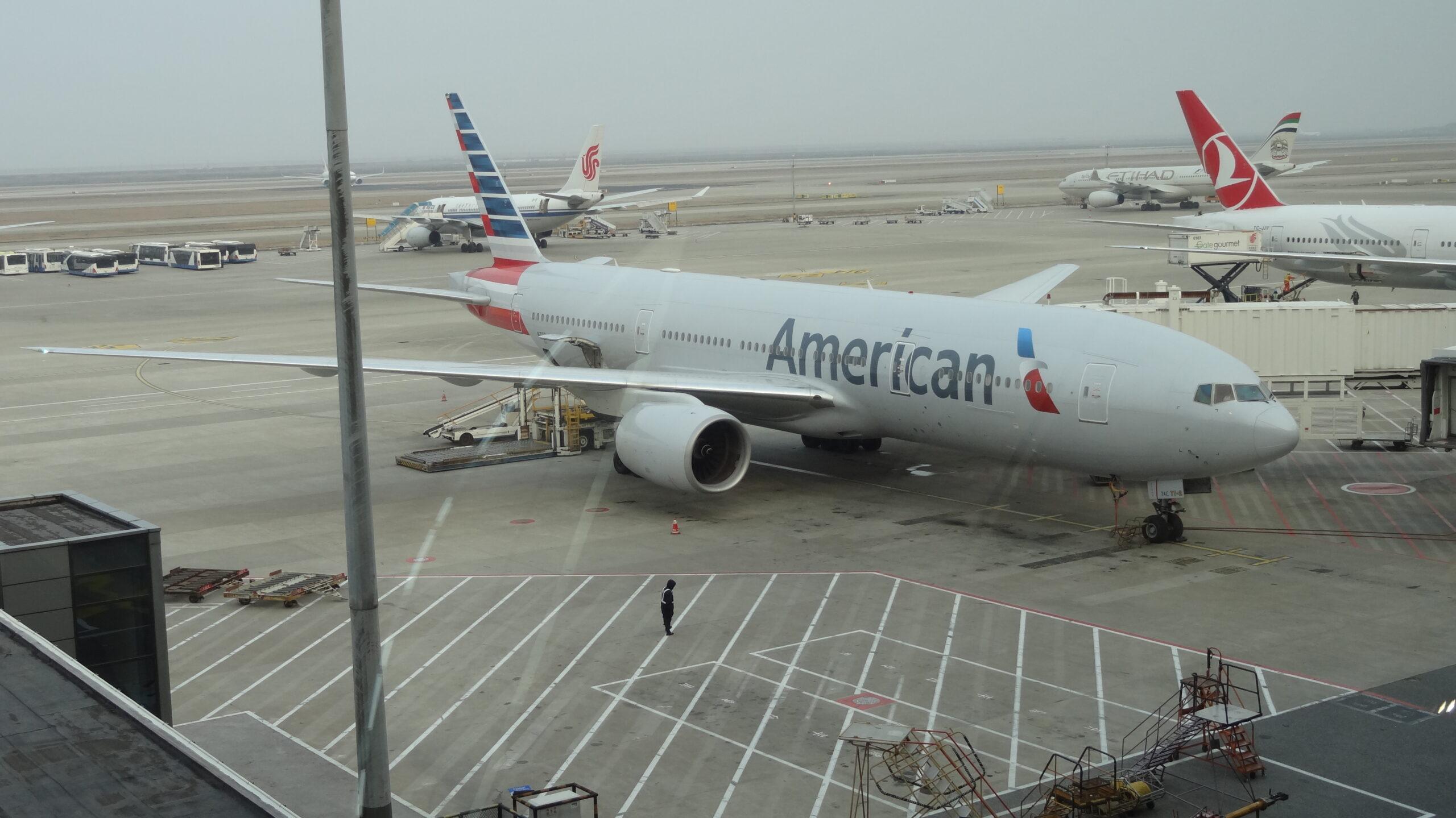 An American Airlines aircraft parked at a terminal gate alongside other international carriers, illustrating the global network of a major airline alliance.