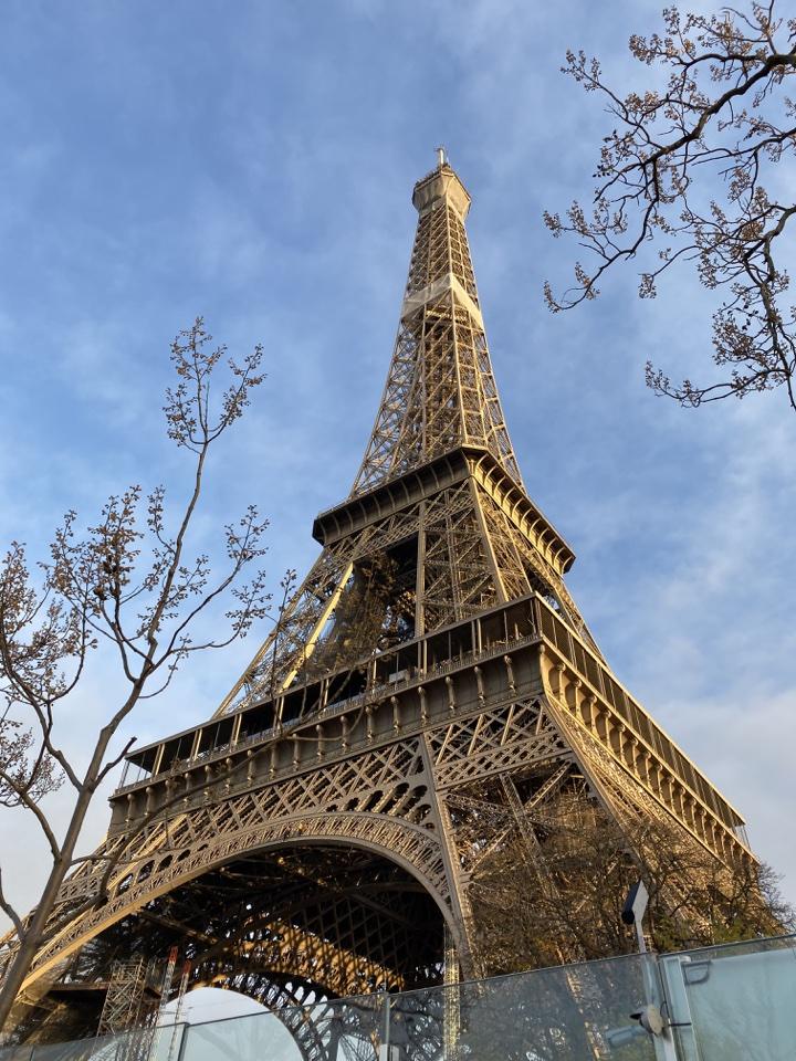 A grand view of the Eiffel Tower monument, the iconic wrought-iron lattice structure on the Champ de Mars in Paris.