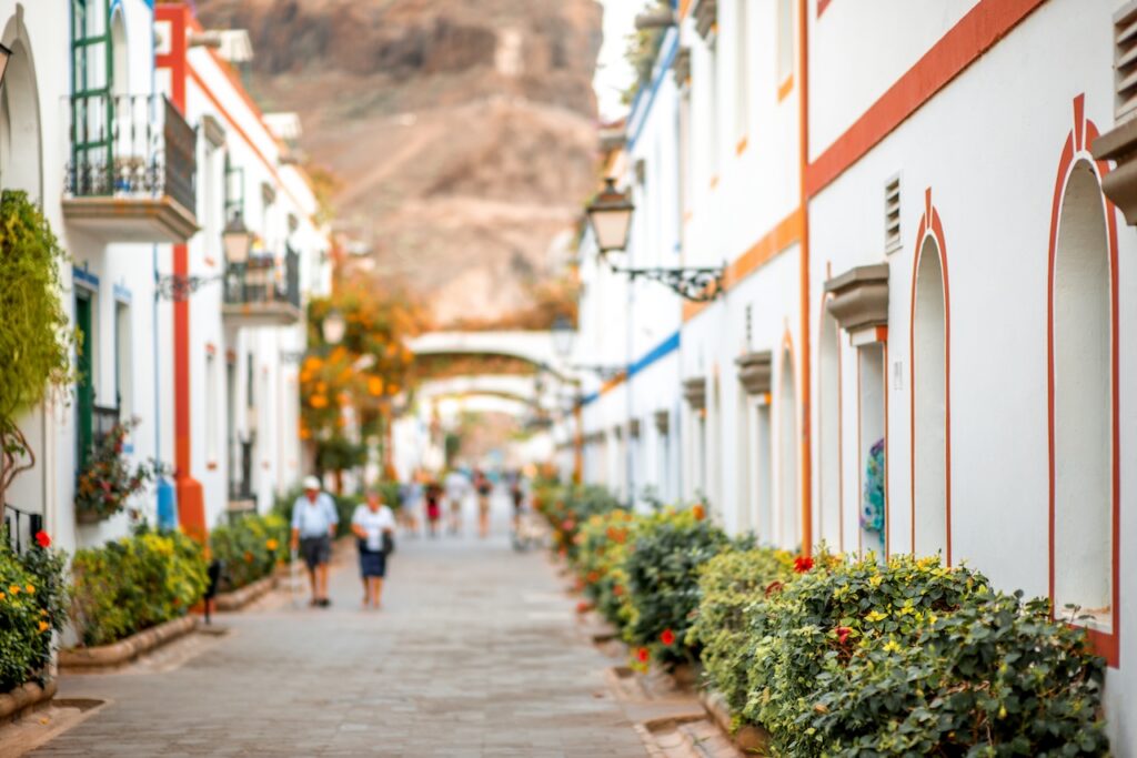 A beautiful view of a European-style street with colorful houses and lush planters, highlighting cultural charm and travel scenery.