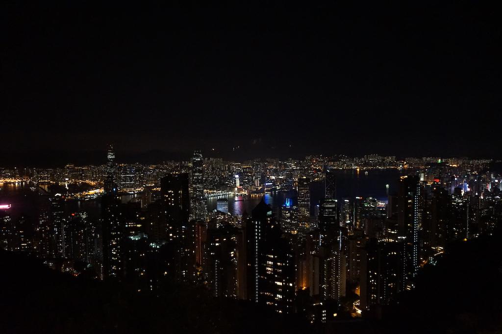 A breathtaking night view of the illuminated Hong Kong skyline and Victoria Harbour as seen from the high vantage point of Victoria Peak, a must-see for anyone who plans to travel Hong Kong.