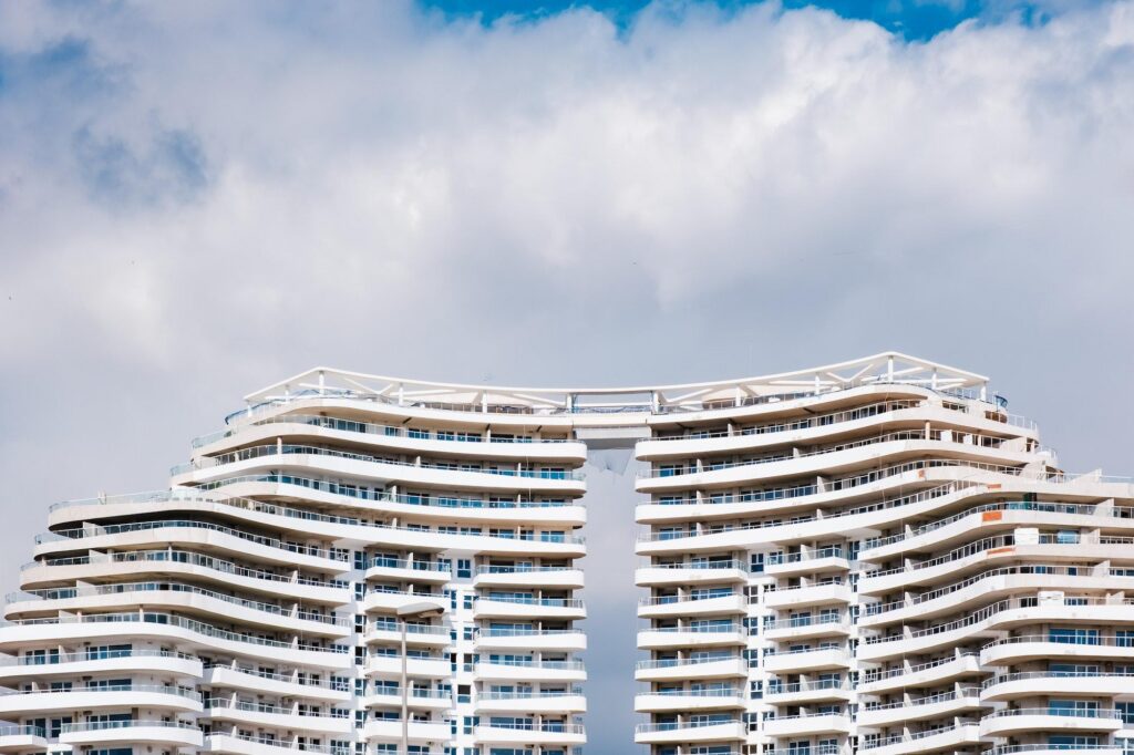 Modern multi-story Four Seasons hotel with curved balconies and unique top design