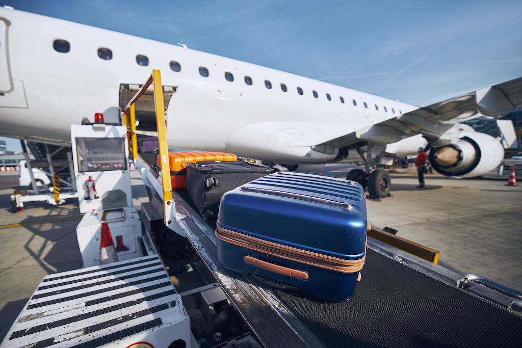 Suitcases moving along a conveyor belt toward an aircraft, a moment that often sparks worries about lost luggage.