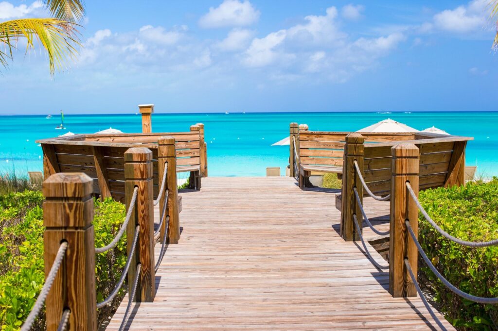 An aerial view of the turquoise waters and white sand of Grace Bay Beach, a premier destination for those visiting Turks and Caicos.