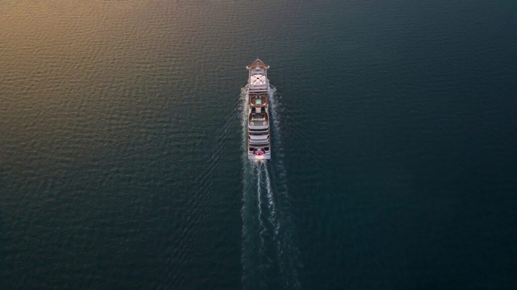 Aerial view of a luxury yacht cruising on the open sea, highlighting exclusive ocean travel, private boating, and serene marine adventure.