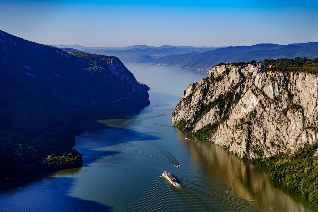 A wide river winding through steep, terraced hills under a clear sky, representing the highly scenic Douro Valley or a similar wine region.