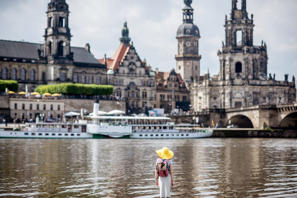 View of the historic city of Dresden, Germany, with the Elbe River in the foreground and baroque architecture in the background.