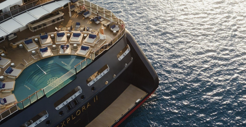 Aerial view of a luxury cruise ship's sun deck and pool, highlighting premium accommodations for a high-end ocean voyage vacation.