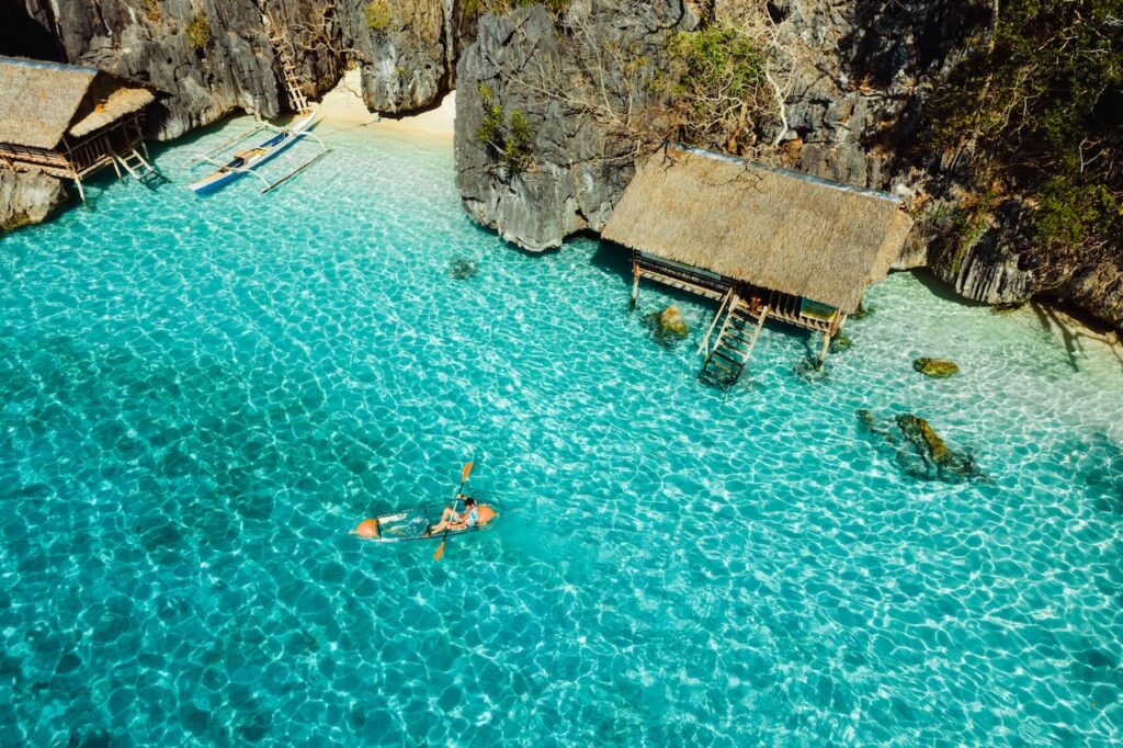 View from a boat entering a secluded cove with towering cliffs, highlighting a top bucket list adventure destination with breathtaking natural beauty.