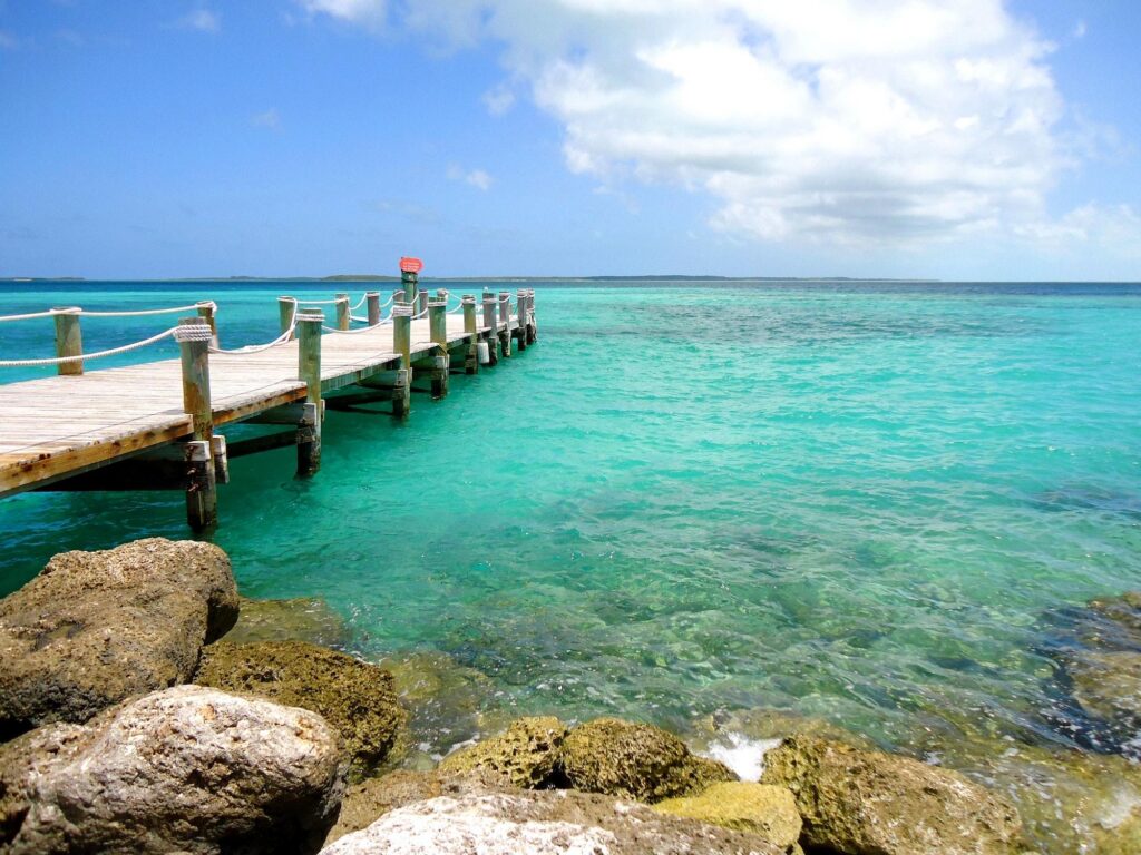 Serene wooden pier over turquoise water for a Bahamas travel guide.