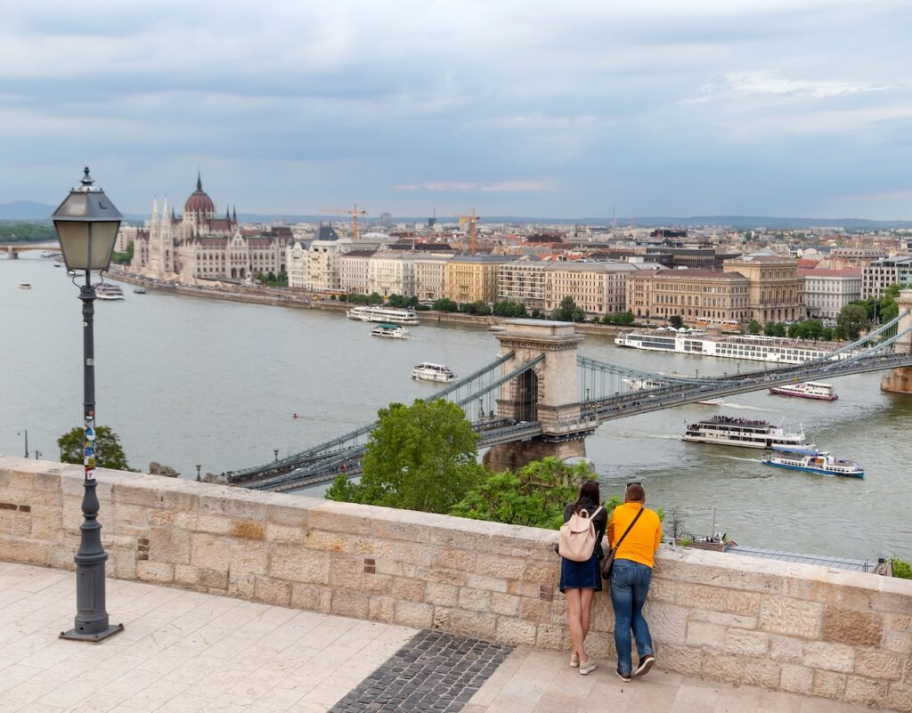 Couple viewing the Danube River and Budapest skyline, representing the destinations covered in a typical first river cruise.