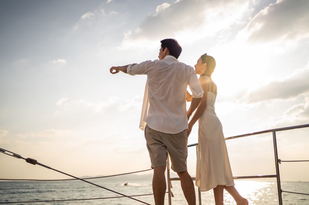 Two couples enjoying the view from the bow of a small yacht, symbolizing the intimate, personalized, and small-scale sailing experience of a luxury vessel.
