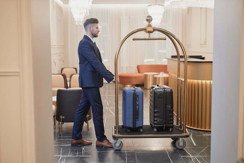 Hotel bellman assisting with luggage check-in, symbolizing the smooth, efficient service and early check-in perks for a luxury weekend getaway.
