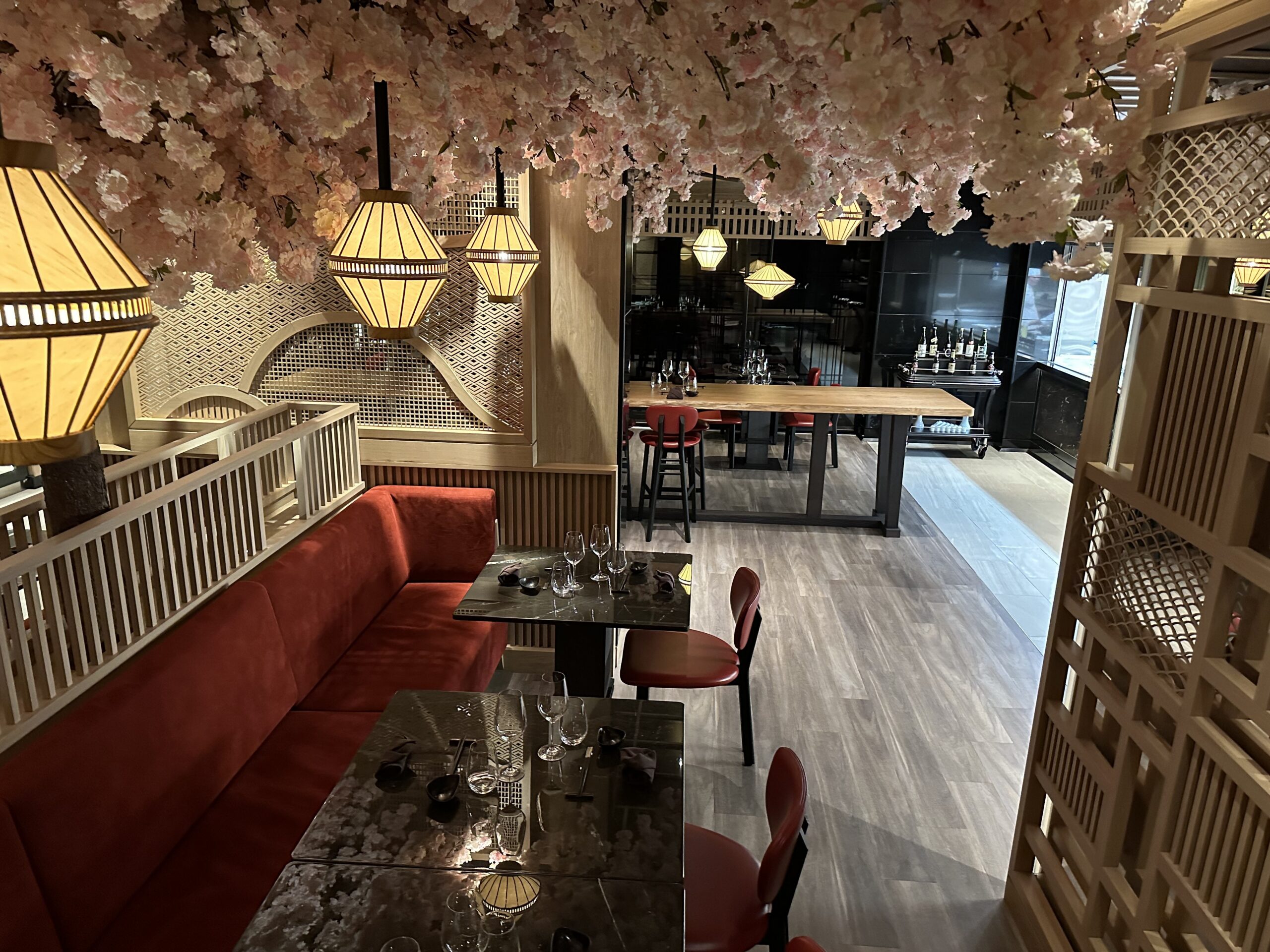 Sakura restaurant dining room aboard Explora Journeys, with cherry blossom canopy and lantern lighting